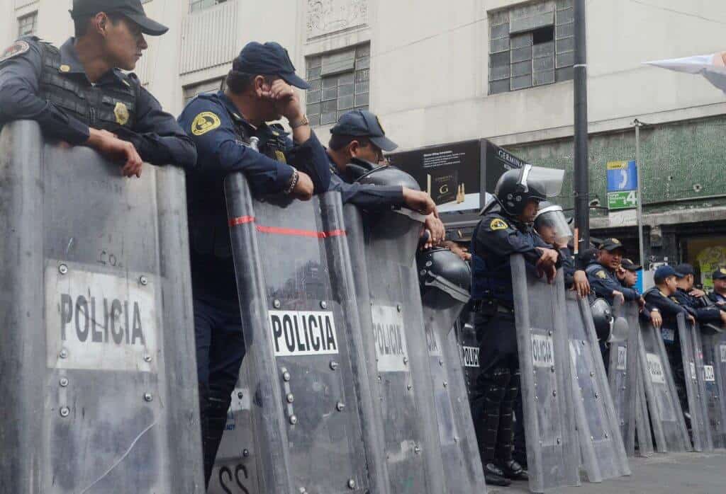 Mexico City Police stand along Balderas Ave during the 43 missing student march in Mexico City on May 26th 2015 .