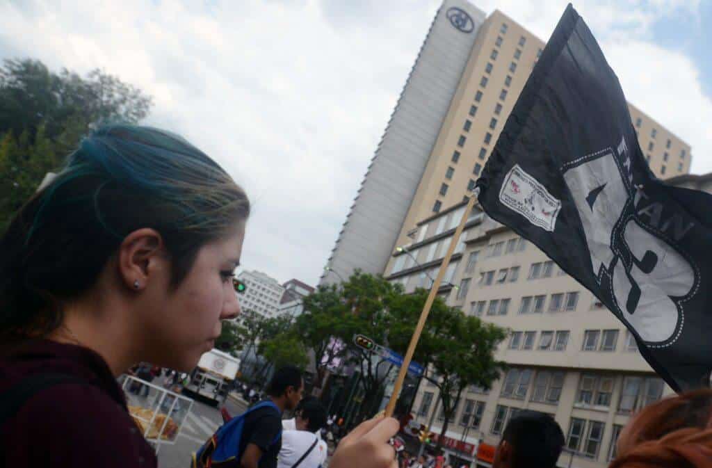 Sara Eslava, 20, of Mexico City waves a flag in support of the 43 missing student during a march in Mexico City on May 26th 2015.